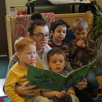 student reading to children in the classroom
