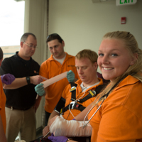 students practicing first-aid on a volunteer